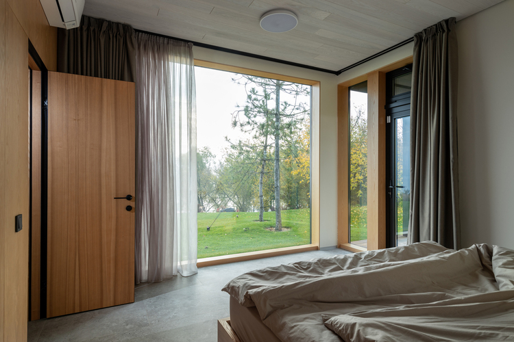 Udobna spavaća soba sa velikim prozorima
